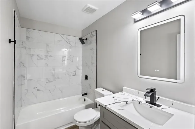 a bathroom with a sink a toilet and a mirror