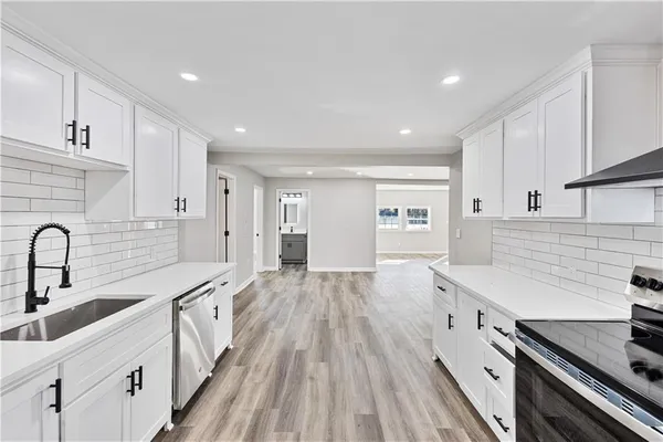 a kitchen with counter top space a sink stainless steel appliances and cabinets