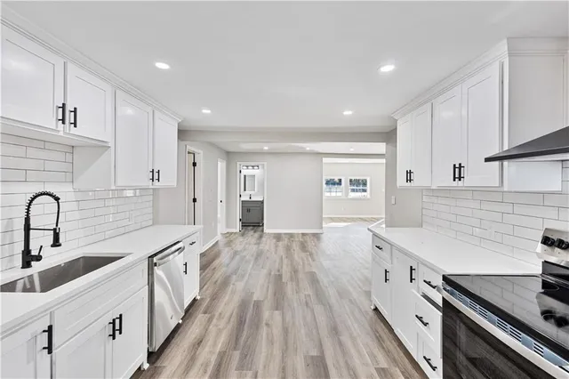 a kitchen with counter top space a sink stainless steel appliances and cabinets