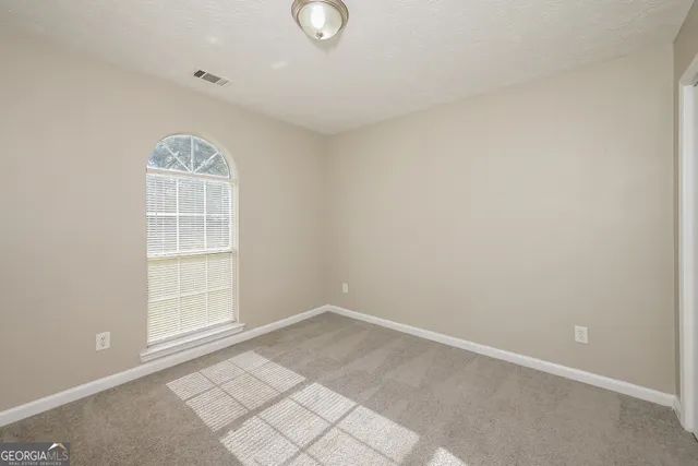 a spacious bathroom with a granite countertop sink a large mirror and shower
