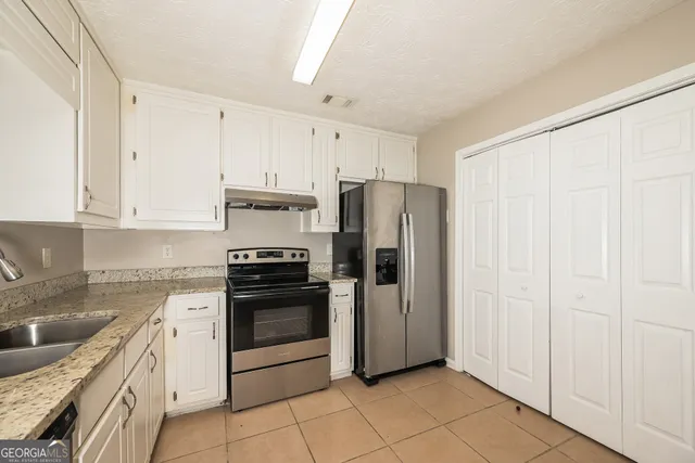 a kitchen with stainless steel appliances granite countertop a refrigerator and a sink