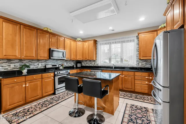 a kitchen with stainless steel appliances granite countertop a stove a sink and a refrigerator