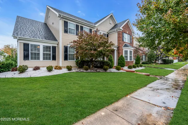 a front view of a house with a yard and potted plants