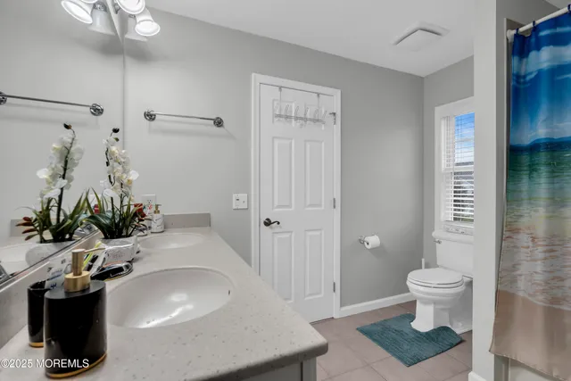 a bathroom with a sink a toilet and shower curtain