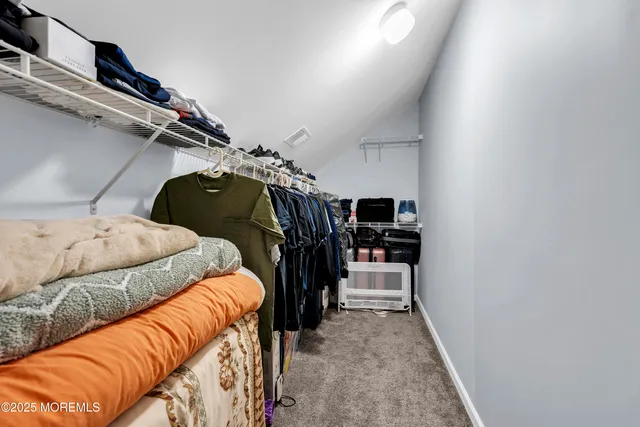 a view of walk in closet with clothes and shoes