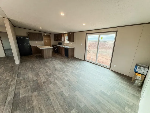 an empty room with wooden floor and entrance