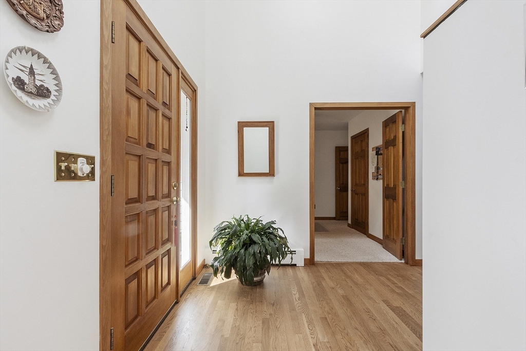 22 Kettle Hole Road Bolton, MA 01740 - Photo 5 of 42 a view of a hallway with wooden floor and a living room