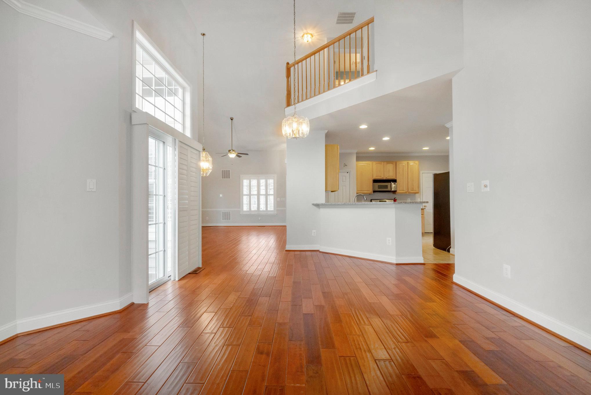 13428 Fieldstone Way Gainesville, VA 20155 - Photo 13 of 46 a view of a big room with wooden floor and a kitchen