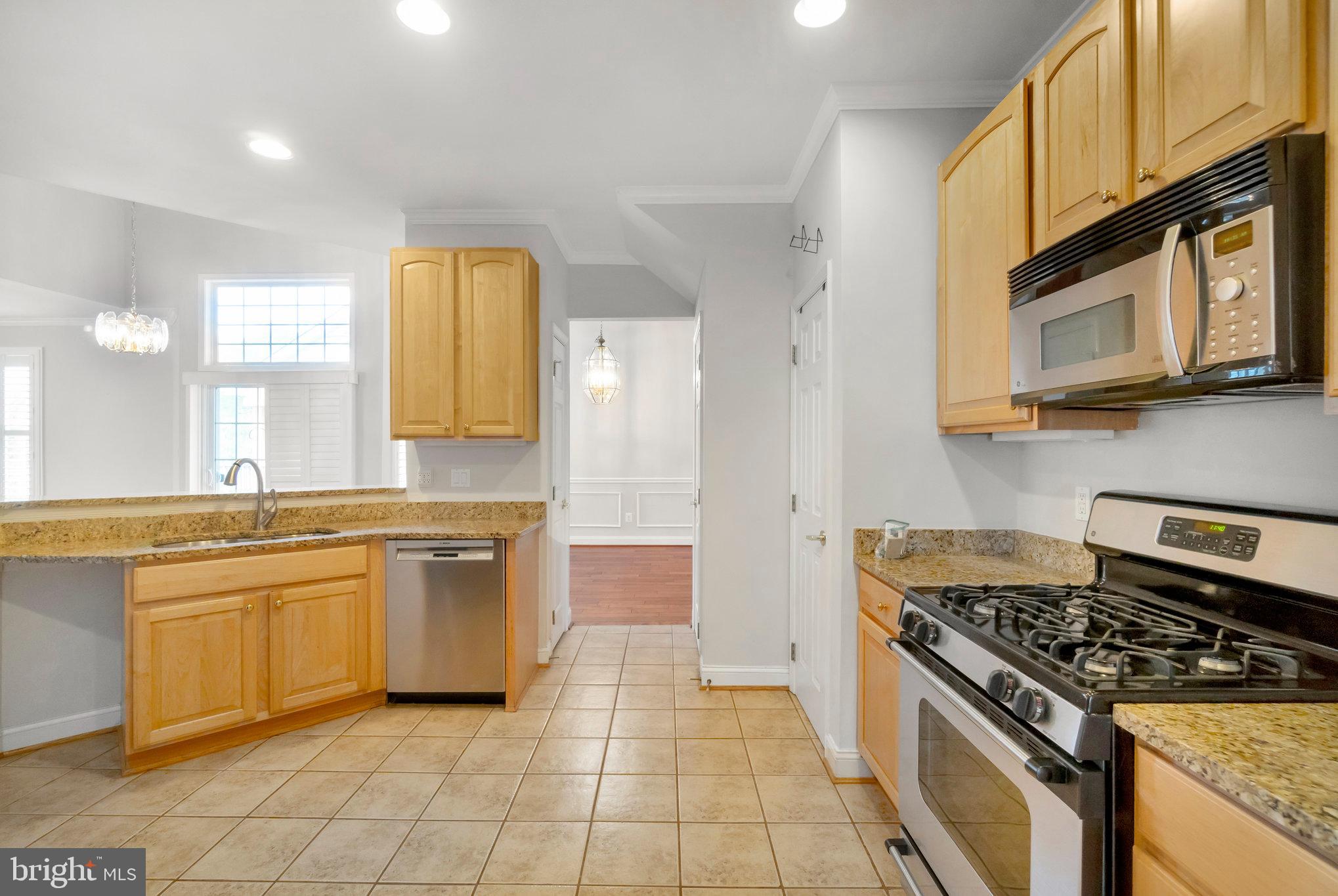 13428 Fieldstone Way Gainesville, VA 20155 - Photo 18 of 46 a kitchen with stainless steel appliances granite countertop a stove a sink and a microwave