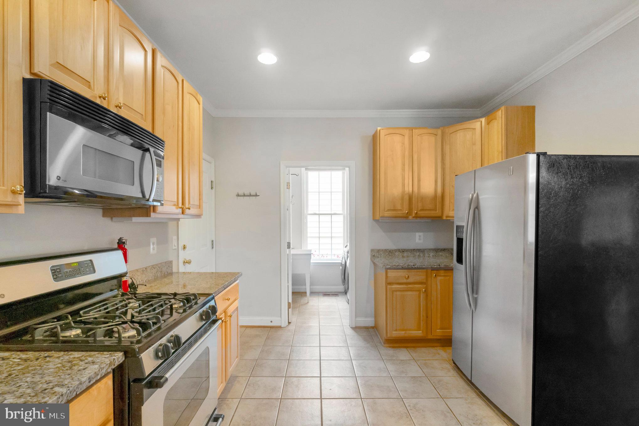 13428 Fieldstone Way Gainesville, VA 20155 - Photo 19 of 46 a kitchen with a stove a refrigerator and a microwave