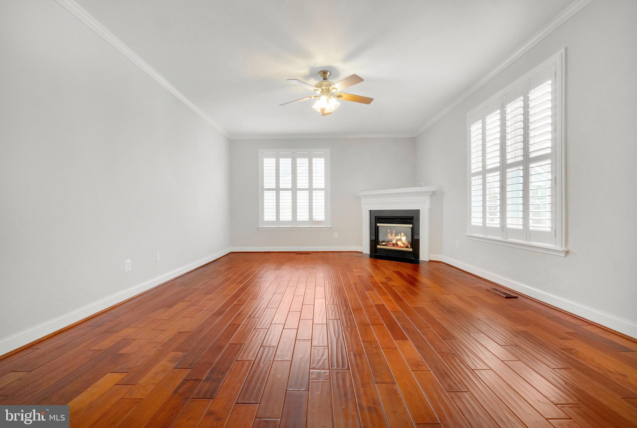 13428 Fieldstone Way Gainesville, VA 20155 - Photo 26 of 46 an empty room with wooden floor fireplace and windows