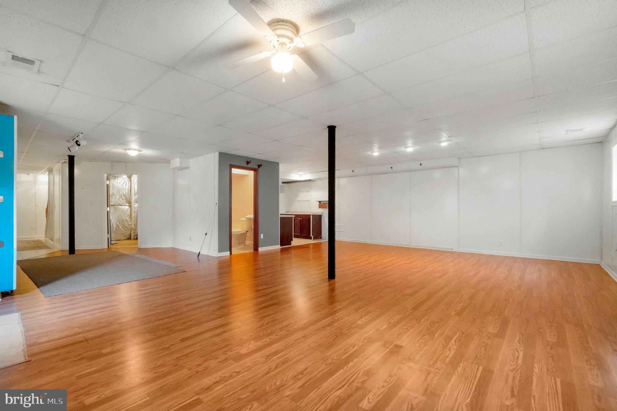 13428 Fieldstone Way Gainesville, VA 20155 - Photo 33 of 46 a view of an empty room with wooden floor and a kitchen