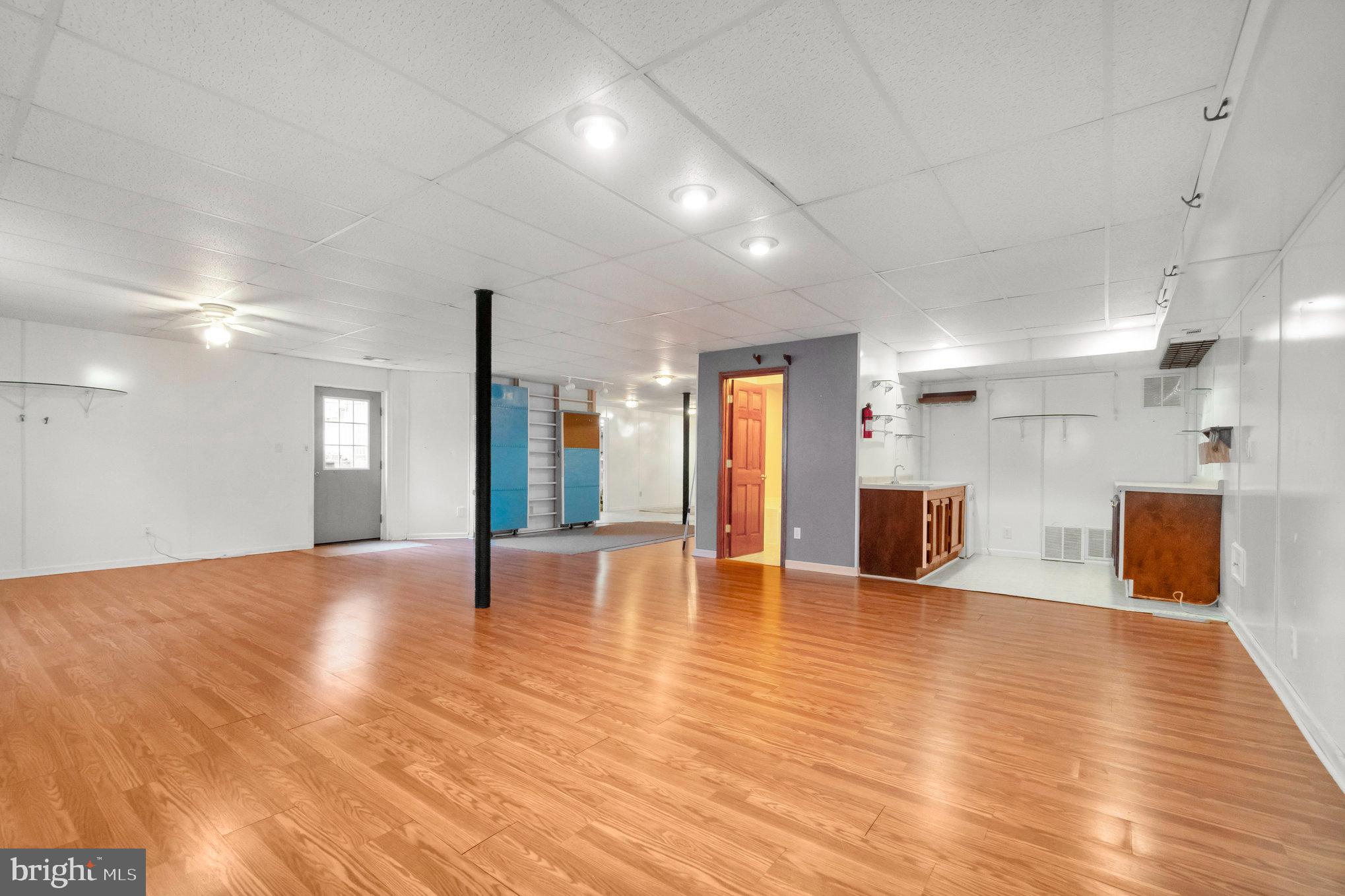 13428 Fieldstone Way Gainesville, VA 20155 - Photo 39 of 46 a view of an empty room with wooden floor and a kitchen