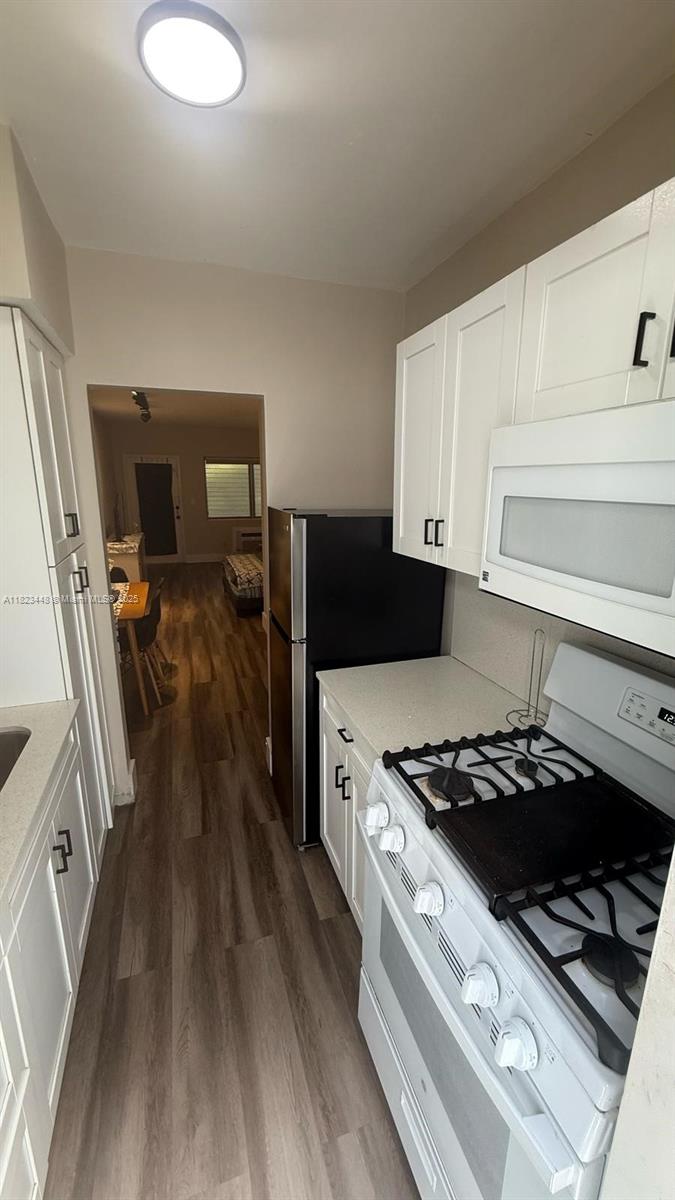 8132 Harding Avenue, Unit 2 Miami Beach, FL 33141 - Photo 15 of 20 a kitchen with wooden floor and a stove top oven