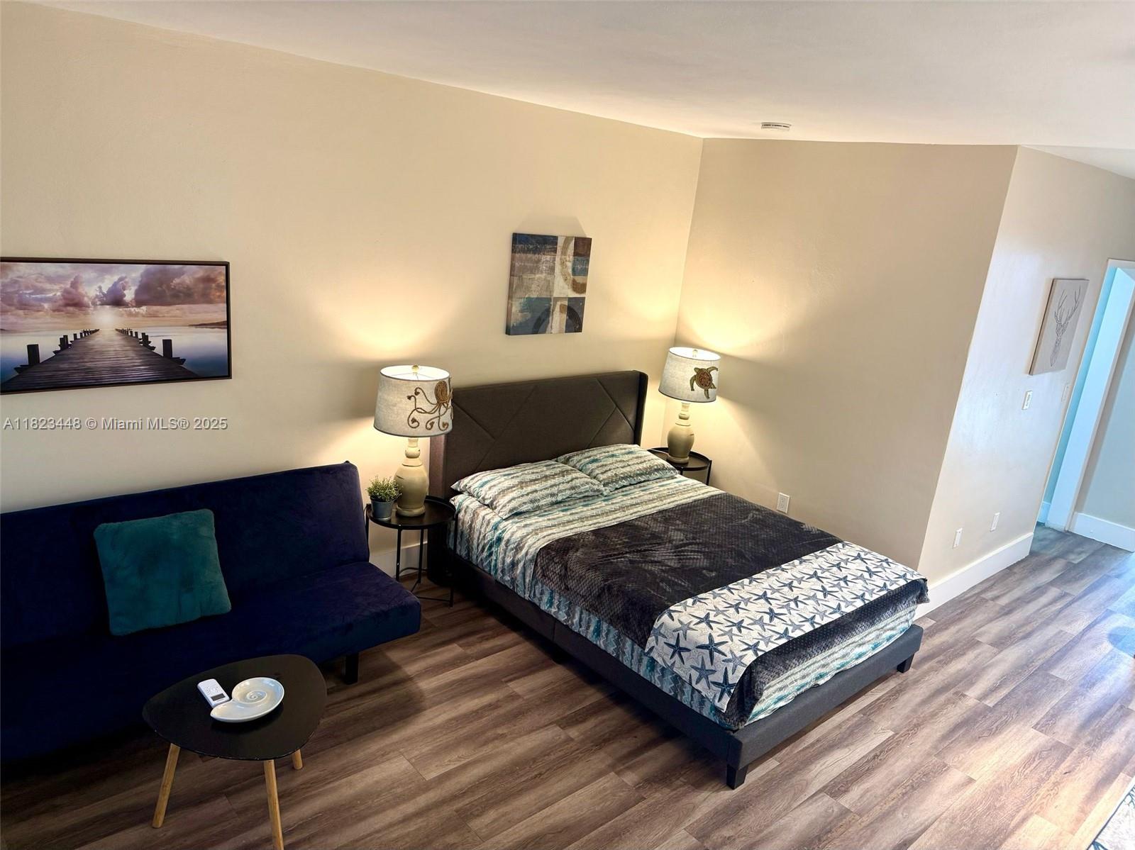 8132 Harding Avenue, Unit 2 Miami Beach, FL 33141 - Photo 3 of 20 a bedroom with a bed lamp and wooden floor