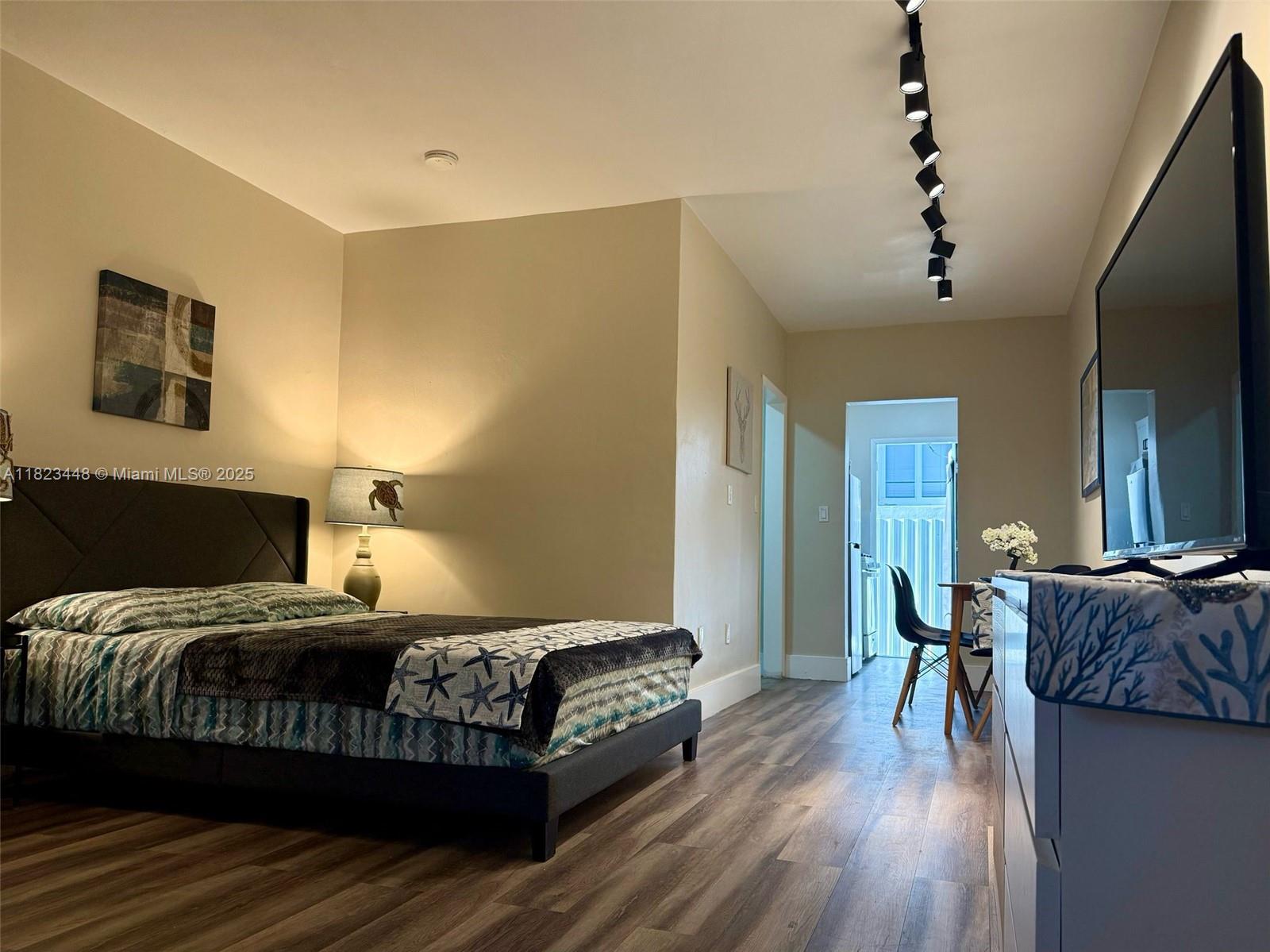 8132 Harding Avenue, Unit 2 Miami Beach, FL 33141 - Photo 6 of 20 a bedroom with a bed and wooden floor