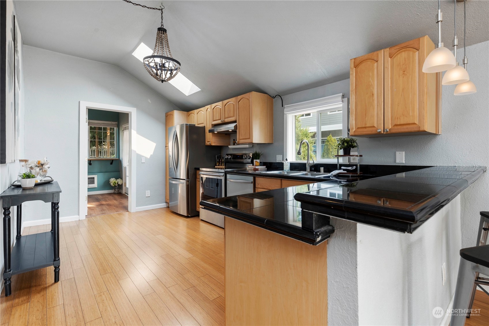 313 Earlington Avenue Southwest Renton, WA 98057 - Photo 6 of 35 a kitchen with granite countertop stainless steel appliances a stove a sink a refrigerator wooden floor cabinets and dining table