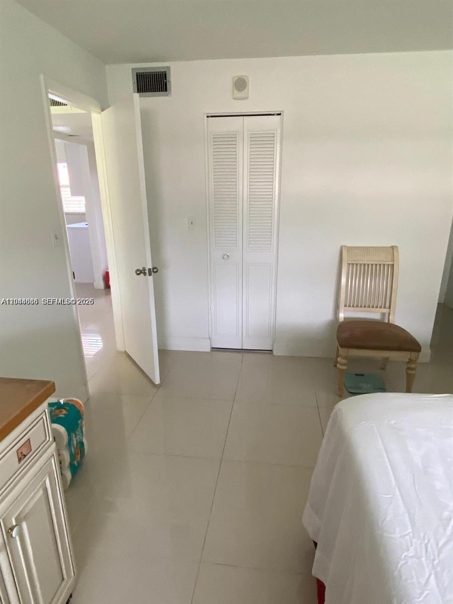 8838 West McNab Road, Unit 104 Tamarac, FL 33321 - Photo 9 of 23 a bedroom with a bed and a mirror