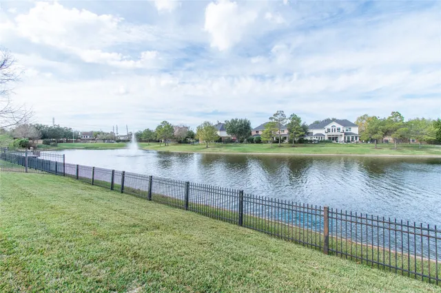 a lake view with a big yard and large trees