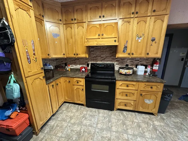 a kitchen with stainless steel appliances granite countertop a sink a stove and a refrigerator