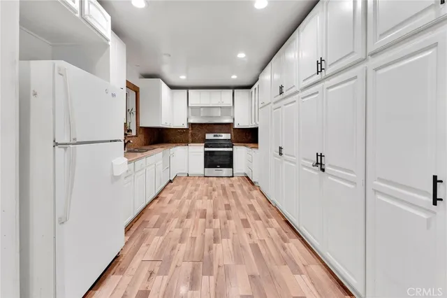 a kitchen with white cabinets and white appliances