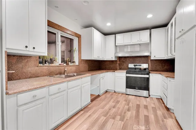 a kitchen with granite countertop white cabinets and white appliances