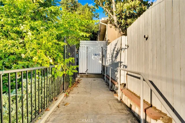 a view of a pathway of a house with wooden fence