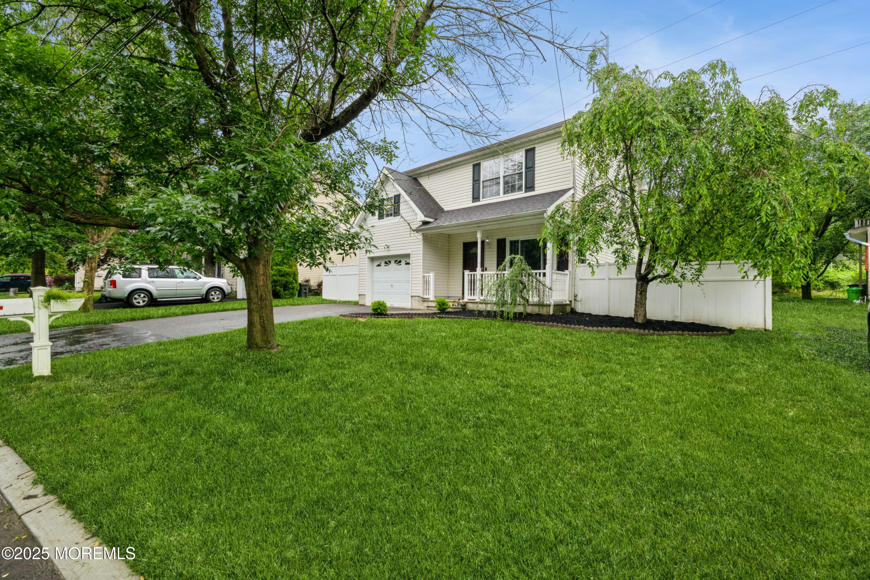 11 Water Street Aberdeen, NJ 07747 - Photo 3 of 25 a front view of a house with a garden and trees