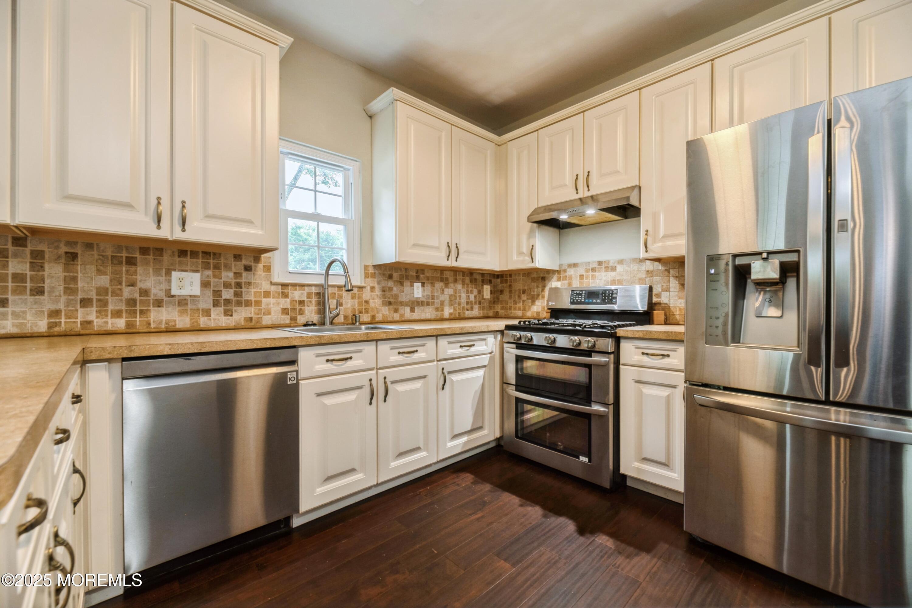 11 Water Street Aberdeen, NJ 07747 - Photo 8 of 25 a kitchen with cabinets stainless steel appliances and wooden floor