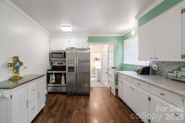 a kitchen with refrigerator cabinets and wooden floor