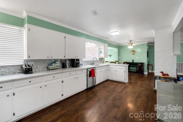a kitchen with granite countertop white cabinets and white appliances