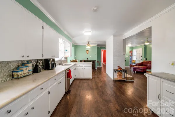 a kitchen with stainless steel appliances sink cabinets and wooden floor