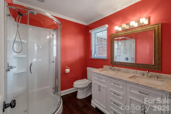 a bathroom with a granite countertop sink toilet a large mirror and shower