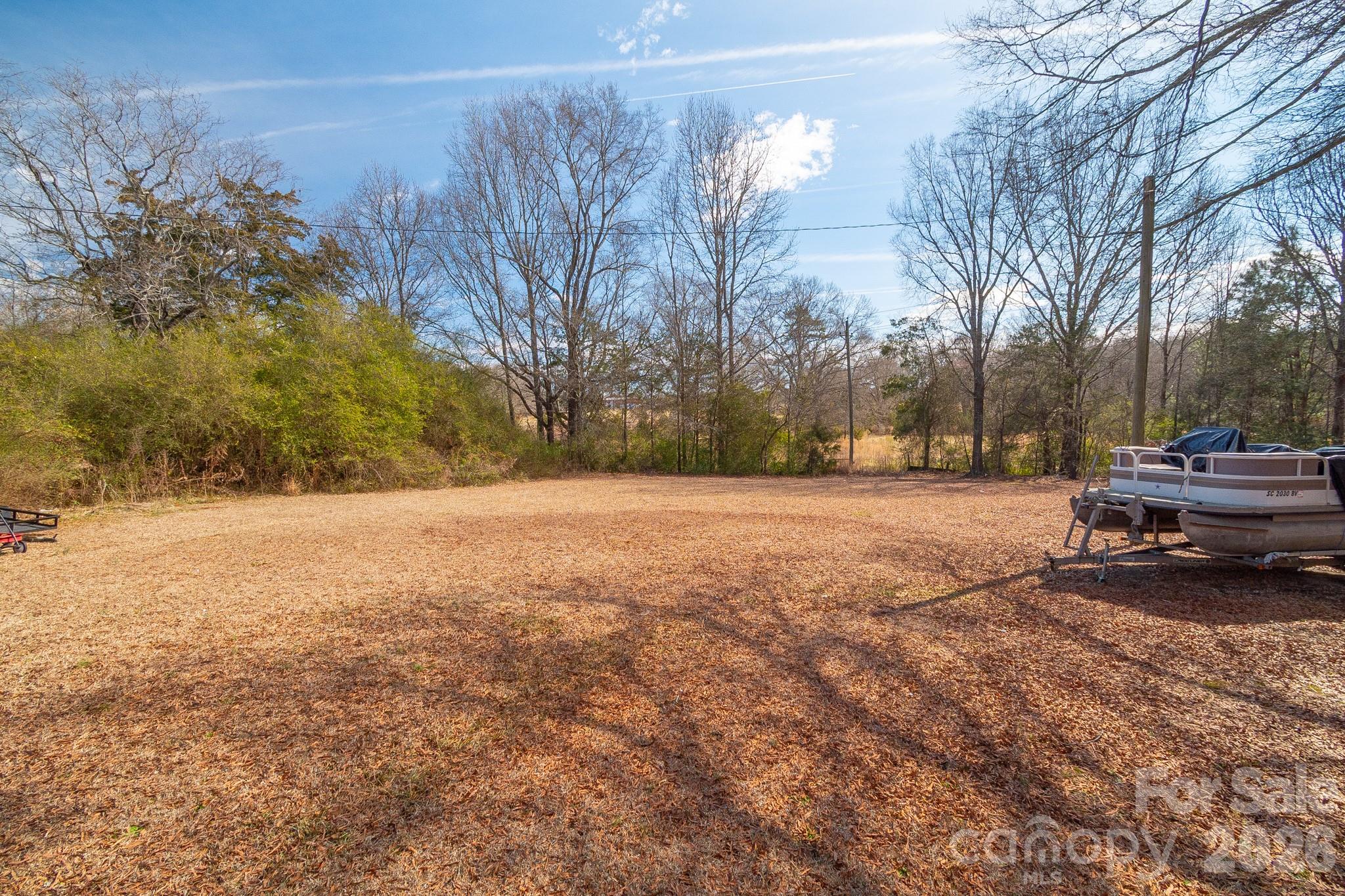 1099 South Potter Road Lancaster, SC 29720 - Photo 40 of 41 a view of dirt yard with a bench and trees around