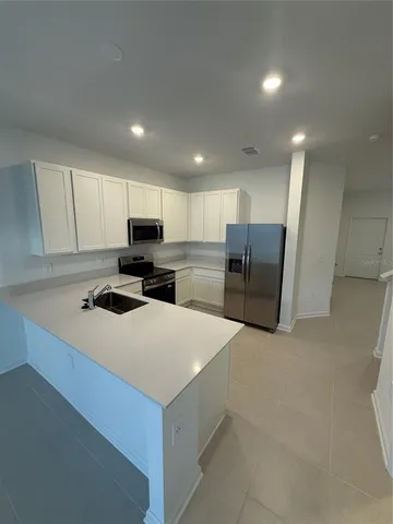 a kitchen with refrigerator and cabinets