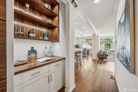 a hallway with a white stove a sink and dishwasher with wooden floor