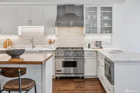 a kitchen with a sink stove top oven and cabinets