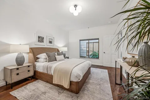 a bedroom with a bed a mirror and lamp