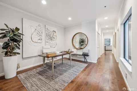 a living room with furniture a window and a clock