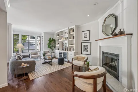 a living room with furniture a fireplace and a large window