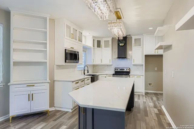 a kitchen with stainless steel appliances granite countertop a sink cabinets and wooden floor