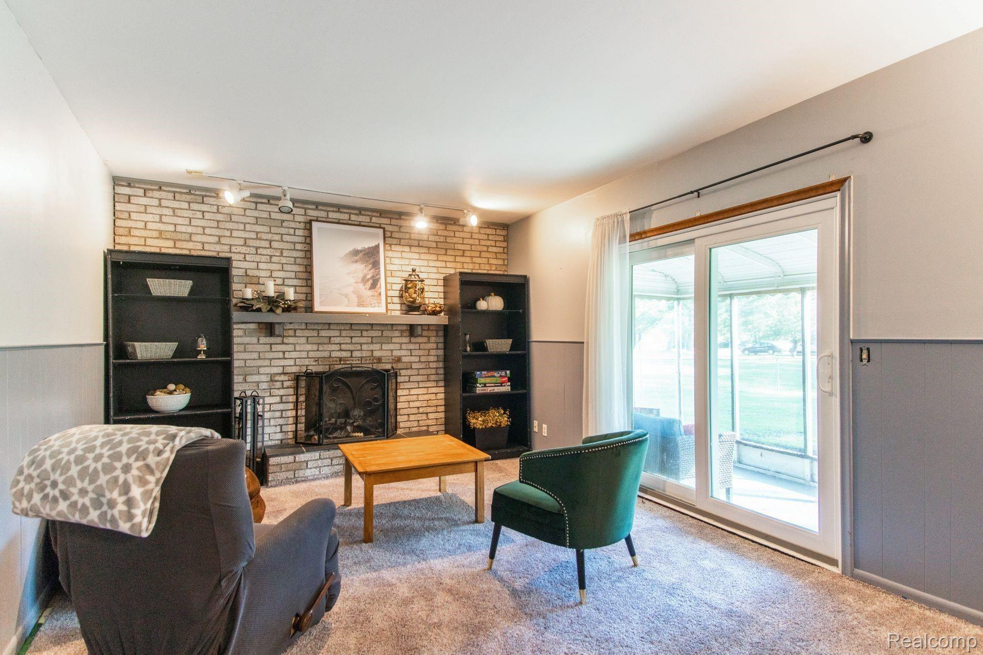 2136 Armond Road Howell, MI 48855 - Photo 6 of 15 Family room with natural fireplace and door wall to enclosed screen room