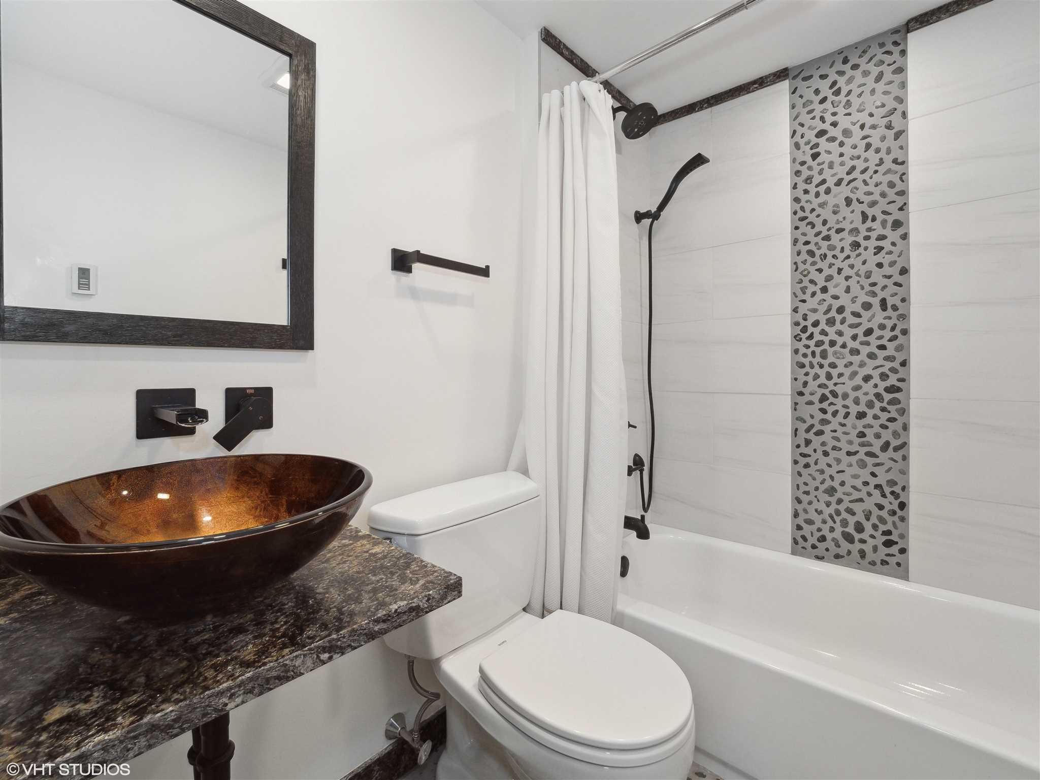 20 John Street Beacon, NY 12508 - Photo 24 of 36 a bathroom with a granite countertop bathtub sink vanity mirror and toilet