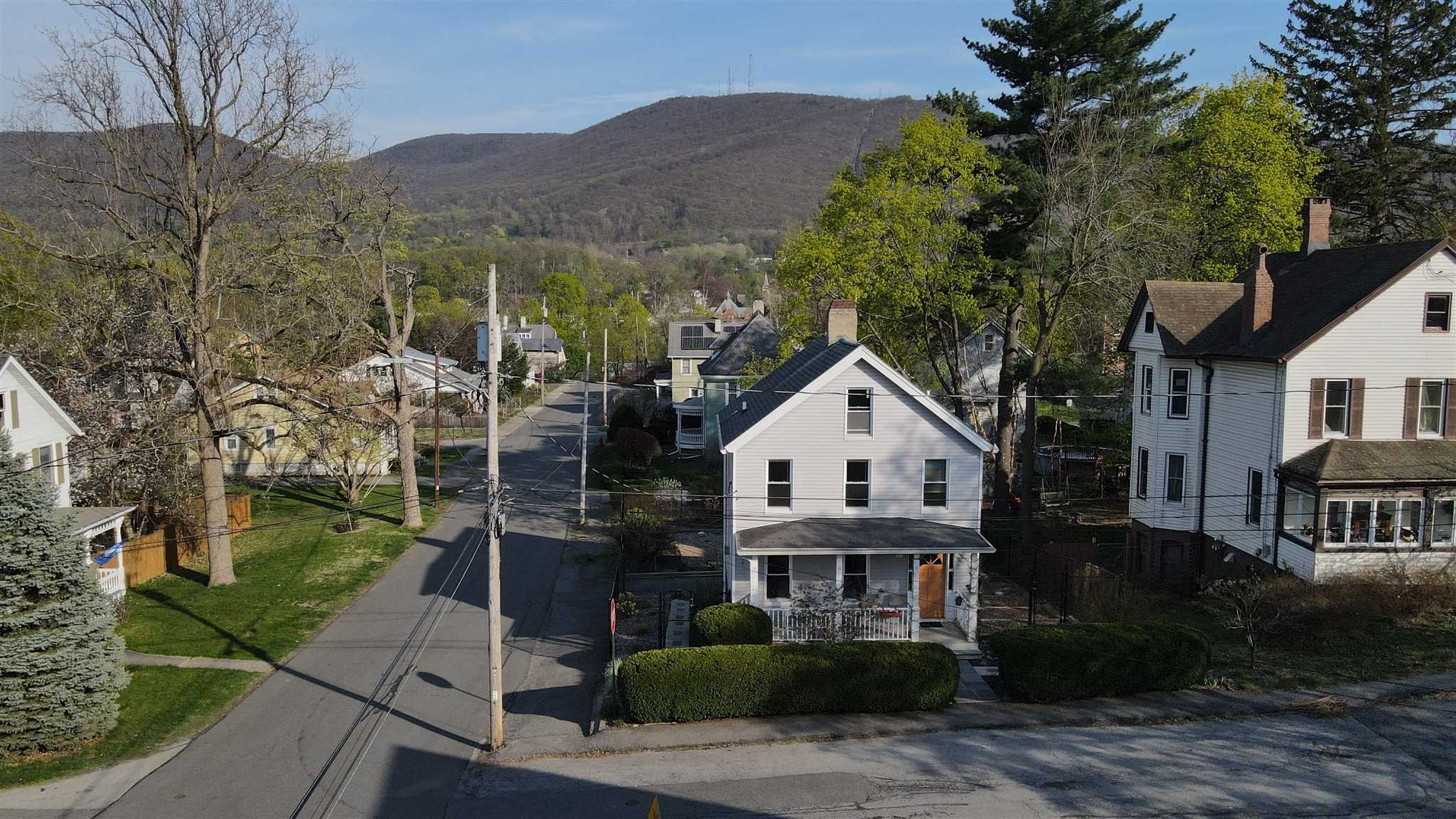 20 John Street Beacon, NY 12508 - Photo 35 of 36 a view of a white house next to a yard with plants and trees