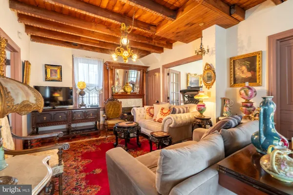 a kitchen with stainless steel appliances kitchen island granite countertop a refrigerator a stove top oven a dining table and chairs with wooden floor