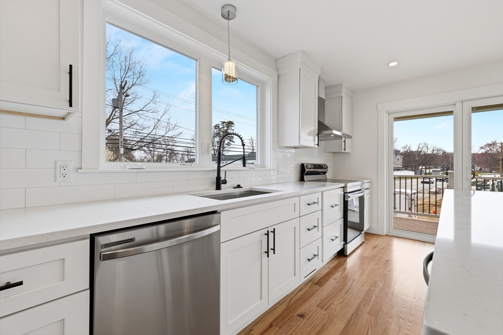 2 Old County Road, Unit 12 Salisbury, MA 01952 - Photo 6 of 29 a kitchen with white cabinets and wooden floors