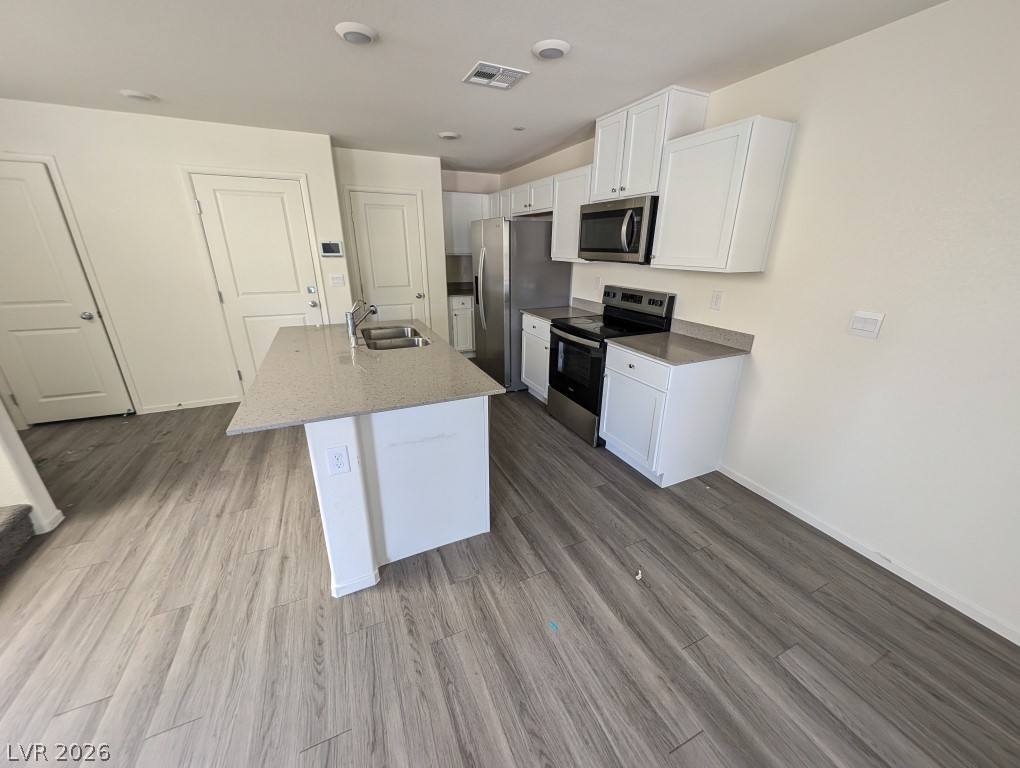 4820 Orchid Rdg Avenue Las Vegas, NV 89141 - Photo 5 of 16 A contemporary kitchen space boasts sleek stainless steel appliances and a generous island with integrated sink.