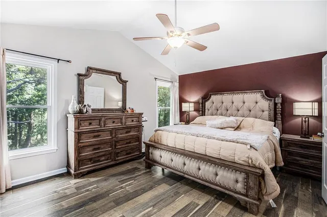 a bedroom with a bed a chandelier and dresser