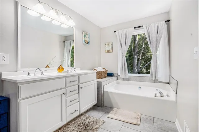 a bathroom with a bathtub a sink and a mirror