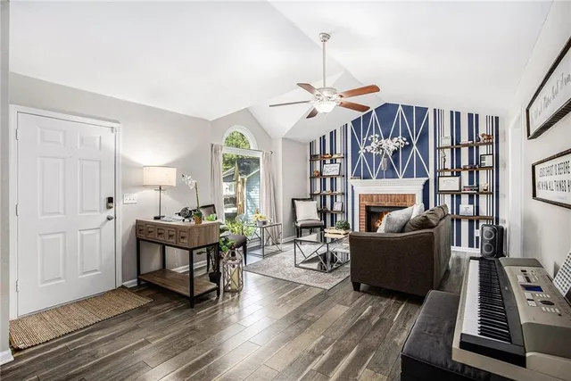 a living room with furniture a fireplace and a chandelier